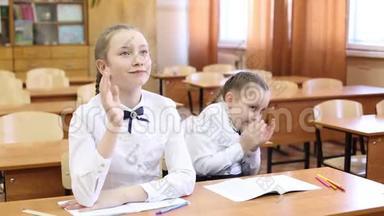 女学生举手回答老师的问题。